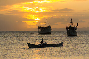 Boats at sea, backlit, at sunset time