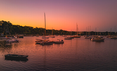 Fototapeta na wymiar Pink sunrise at the marina with moored boats and yachts on Cape Cod in autumn