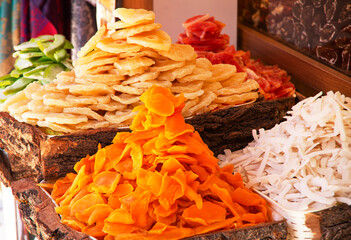 thai dessert in the market. Candied fruits, mango and pineapple wedges. food background,mountain of candied crystallized fruits on a store counter.