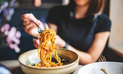 Italian food. woman hand holding fork with spaghetti bolognese sauce in bowl