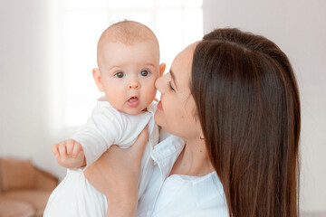 mom holds the baby in her arms at home