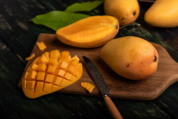 Cut and complete mangoes on the chopping board