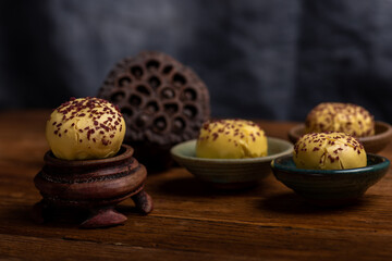 Cut and complete the egg yolk steamed stuffed bun on the wood grain table