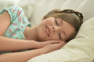 Obraz na płótnie Canvas little girl lying on bed in bedroom