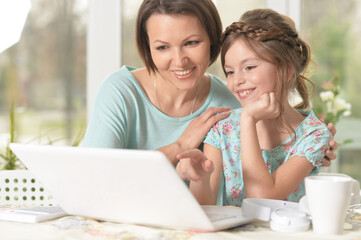 mother and daughter using laptop