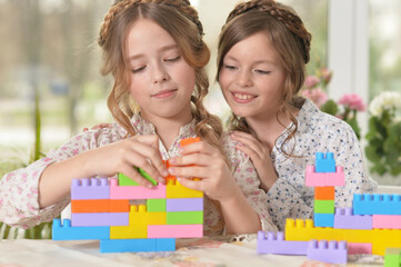 Obraz na płótnie Canvas Beautiful girls with colorful blocks at home