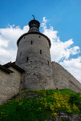 The fortress wall of a medieval fortification with towers against a bright blue sky. © eskstock