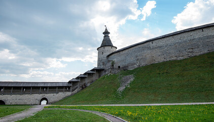 The fortress wall of a medieval fortification with towers against a bright blue sky. © eskstock