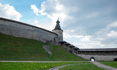 The fortress wall of a medieval fortification with towers against a bright blue sky. © eskstock