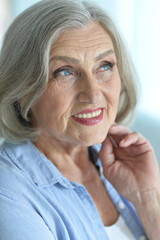 Happy senior woman at home with flowers