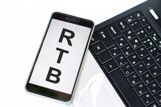 text RTB on the phone screen that lies on the laptop keyboard, business concept