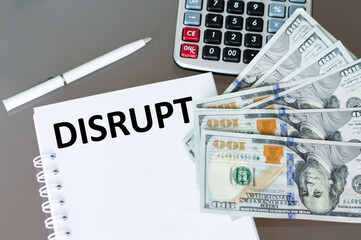 Disrupt text on a notebook on a table next to money, calculator and white pen