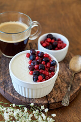 Panna cotta with berries. Wooden background. Side view.