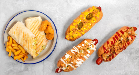 a set of hot dogs and a plate of French fries with nuggets on a white background