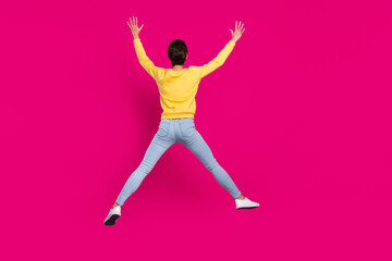 Fototapeta na wymiar Photo of funny funky young lady wear yellow jumper smiling jumping high like star isolated pink color background