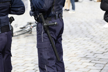 Polscy policjanci w niebieskim mundurze na zabezpieczeniu imprezy w mieście z wyposażeniem służbowym.  - obrazy, fototapety, plakaty