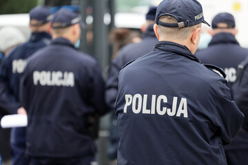 Polscy policjanci w niebieskim mundurze na zabezpieczeniu imprezy w mieście. - obrazy, fototapety, plakaty