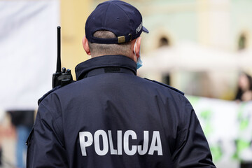 Polscy policjanci w niebieskim mundurze na zabezpieczeniu imprezy w mieście z wyposażeniem...