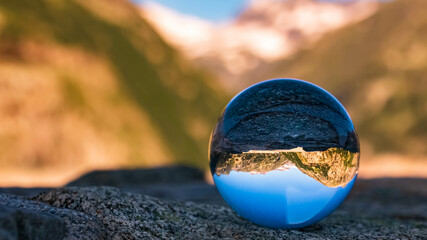 Fototapeta na wymiar Crystal ball alpine landscape shot at the famous Koelnbreinsperre, Maltatal, Kaernten, Austria