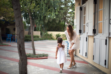 Lovely little girl with mother at summer resort.