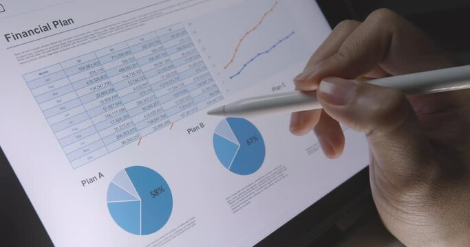 Close-up hand use pen write check growth data number on touch screen laptop note pad app. Loan agent job work at night or MBA tax study in retail graph report  review read saving plan crypto chart.