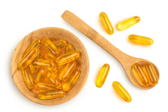 Fish oil capsules in wooden bowl isolated on white background with clipping path and full depth of field. Top view. Flat lay
