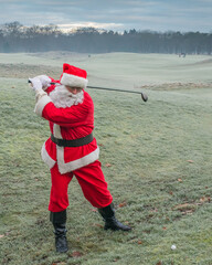 Santa Claus playing golf on a green frosty field, winter christmas holiday, active lifestyle