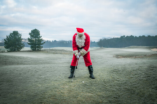 Santa Claus plays golf on a winter field during the Christmas holiday.