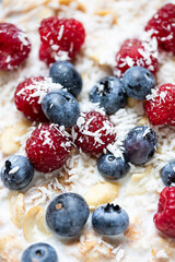 Whole grain oat flakes with fresh ripe blueberries, raspberries, yogurt and vegan almond milk close up. Healthy breakfast concept