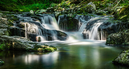 Fototapeta na wymiar Wasserfall im Wald an einem Wildbach