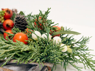 Naklejka na ściany i meble Details of Christmas wreath of fresh spruce, cones and сhristmas decorations, close up. New Year decorations.