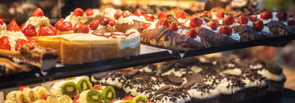 Window shopping on traditional Christmas market in Maastricht, Netherlands. Buying candy, pastry and cake. Choosing cake in bakery.