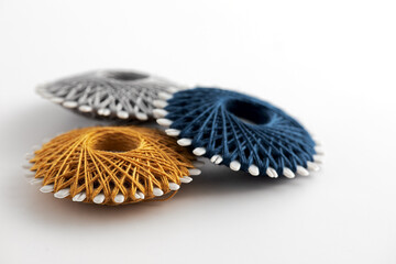 gray, blue and yellow sewing thread on round bobbins