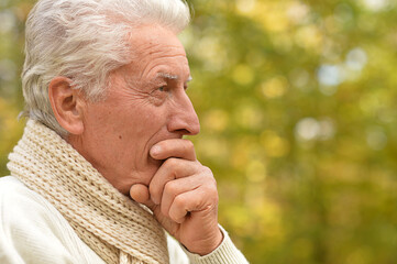 Portrait of a thinking senior man in park praying