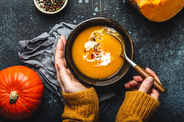 Female hands with bowl of pumpkin soup