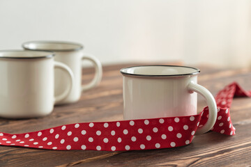 several empty white cups with red tape on wooden table