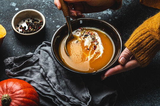 Female hands with bowl of pumpkin soup