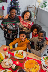 high angle view of joyful african american family looking at camera during christmas dinner
