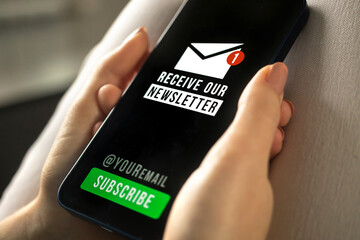 Mobile phone with newsletter signup page close-up in woman hands
