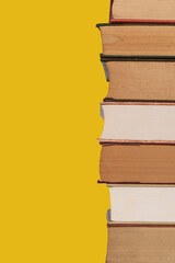 Stacked old books on the right. Isolated on a yellow background. 