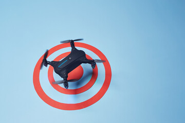 Aerial top down view on isolated drone copter with spinning propellers flying above the reached red...