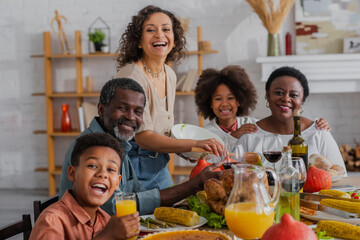 Smiling african american family looking at camera near thanksgiving dinner