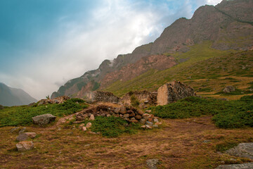 Piles of stones and ruins against the background of mountains in the fog