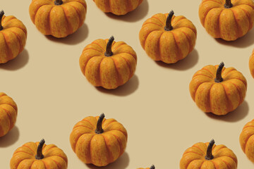 Autumn pattern in yellow and orange colour. Halloween mini pumpkins minimal background. Creative layout.