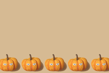 Autumn pattern in yellow and orange colour. Halloween mini pumpkins minimal background. Creative layout. Happy smiling pumpkin face.