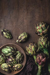Fresh artichokes, various types: Purple globe (romanesco del Lazio IGP) and white globe. Vegetables with antioxidants and phytonutrients. Ingredients of Mediterranean cuisine, rustic style 