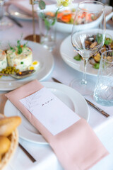 Menu mockup with glasses, flower fork, knife served for dinner in restaurant with cozy interior