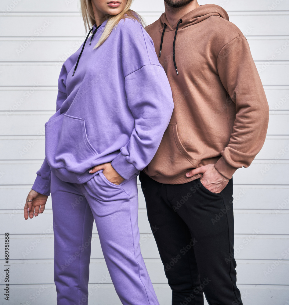 Sticker young bearded man and blonde girl is standing in plain hoodie for logo printing. Clothing mockup for hoodie. Autumn youngsters streetwear