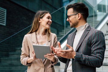 Portrait of successful business people working, talking together in urban background.