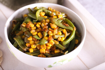 salad with corn green beans and onions is on the table